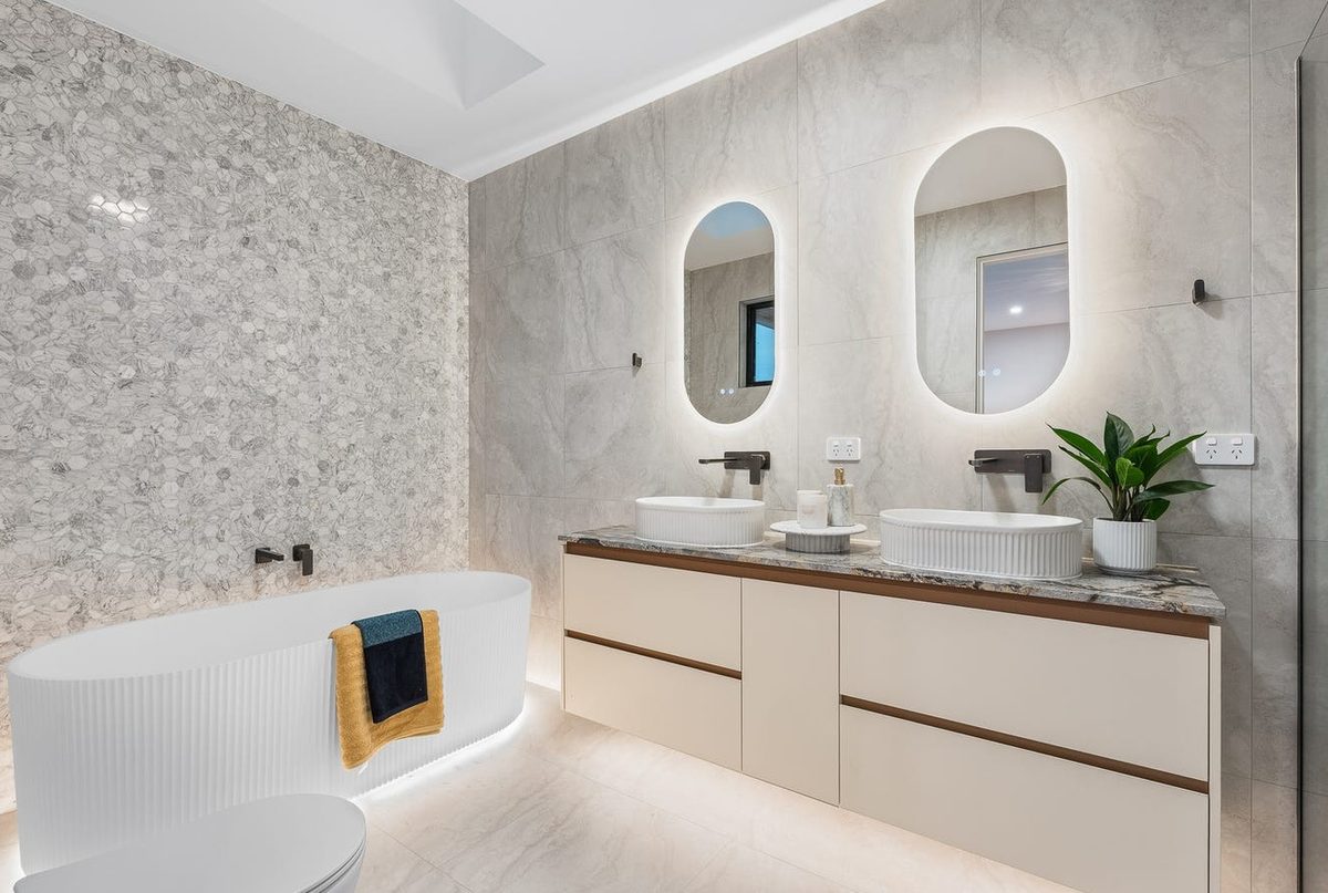 Ensuite bathroom with backlit mirrors and double vanity