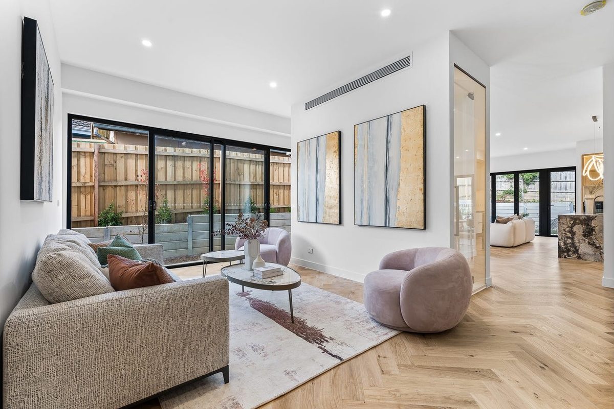 Open-plan living area with herringbone flooring and statement armchairs