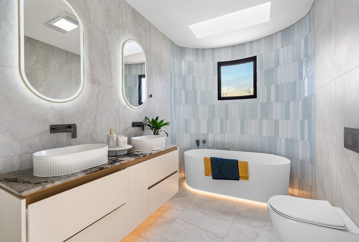 Freestanding bathtub with feature tiled wall and double vanity