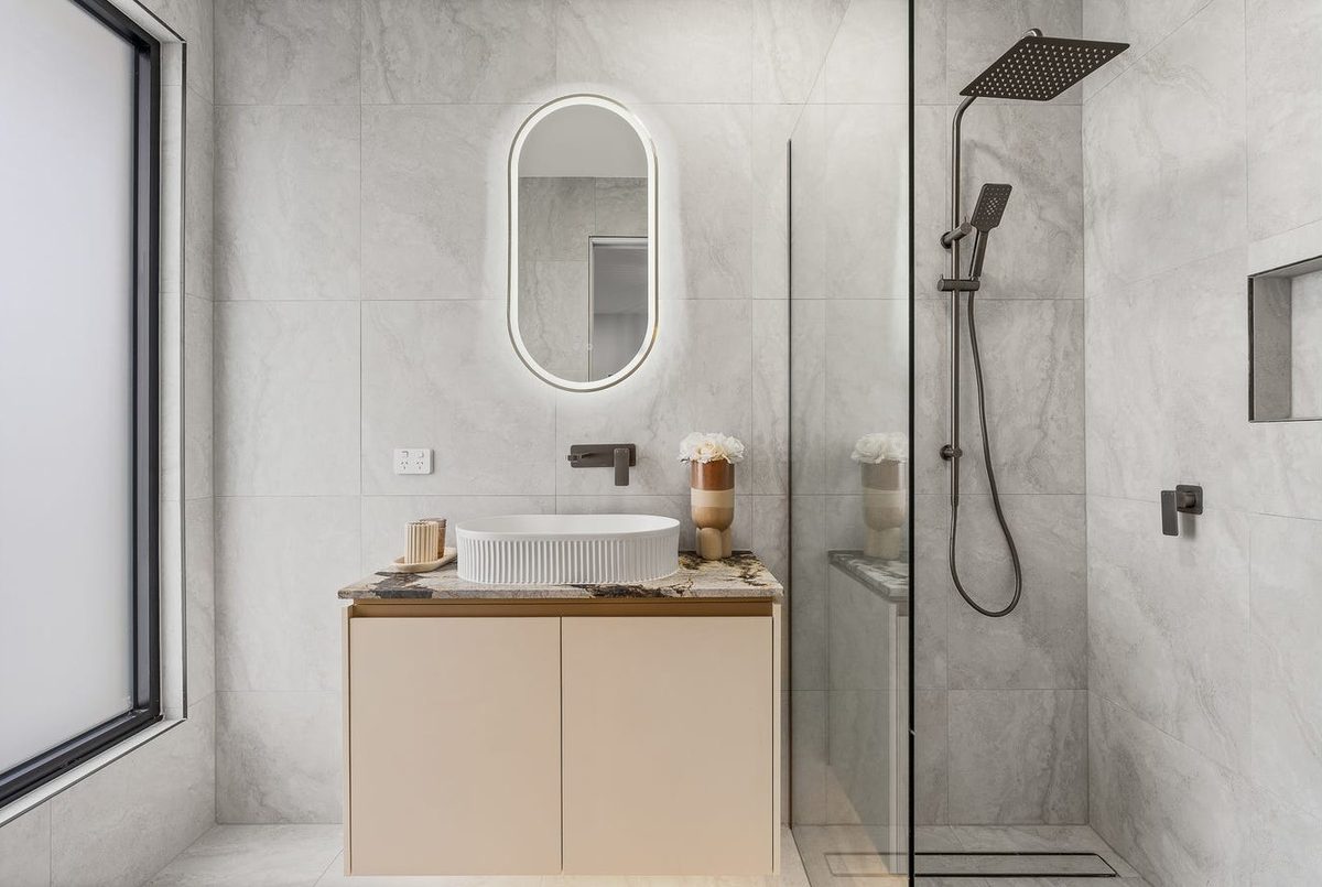 Bathroom vanity and rainfall shower with backlit mirror