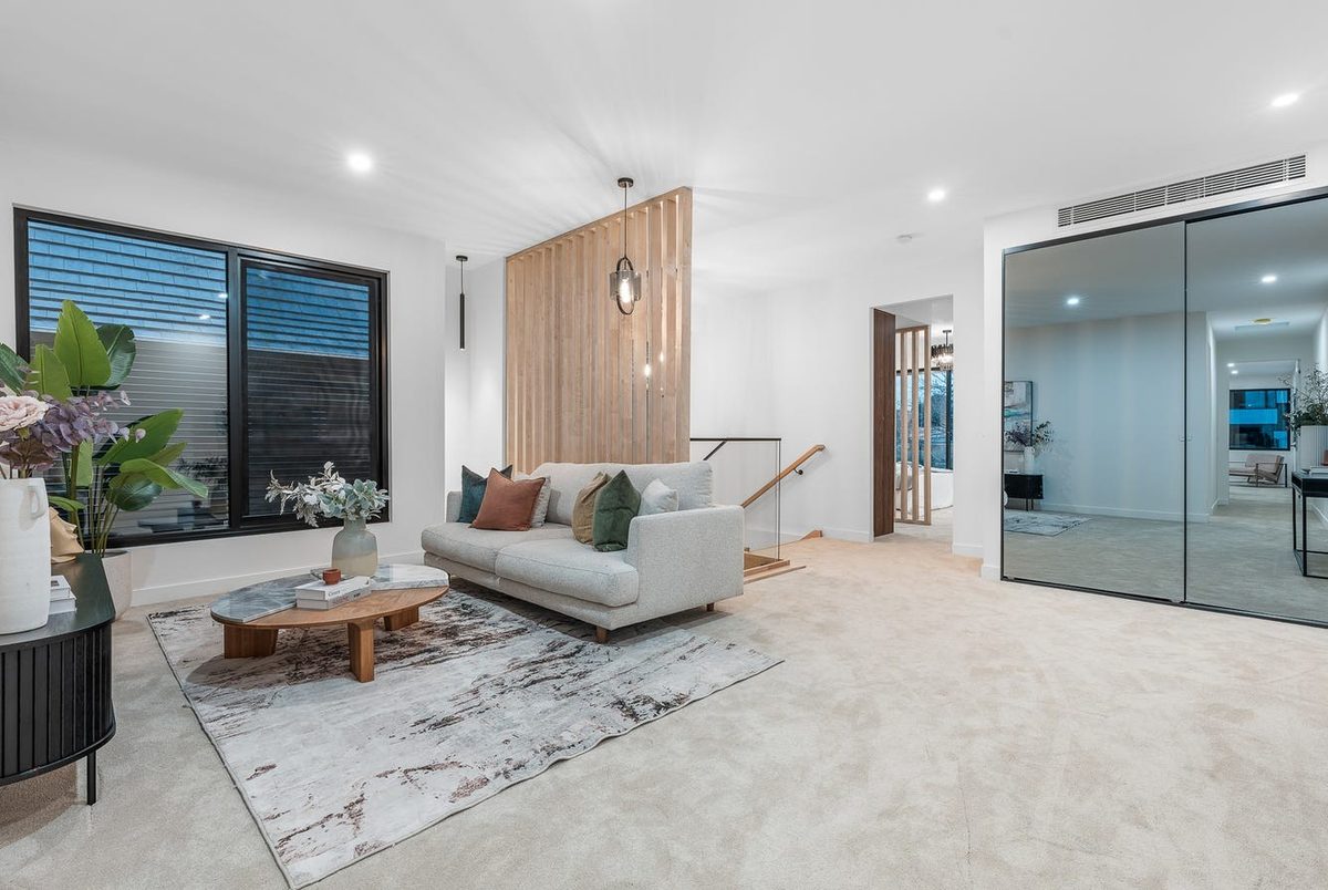 Open-plan living area with feature pendant lighting and staircase