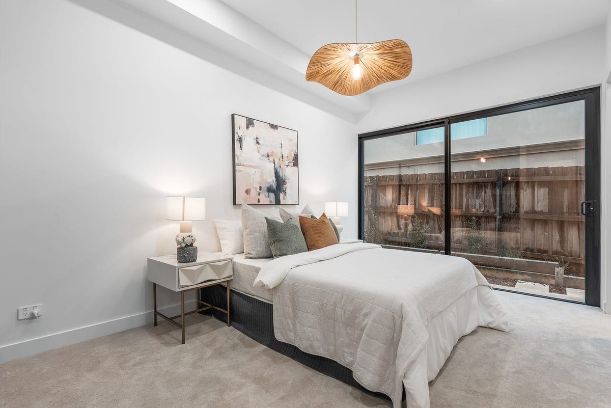 Bedroom with pendant lighting and sliding door access to the yard