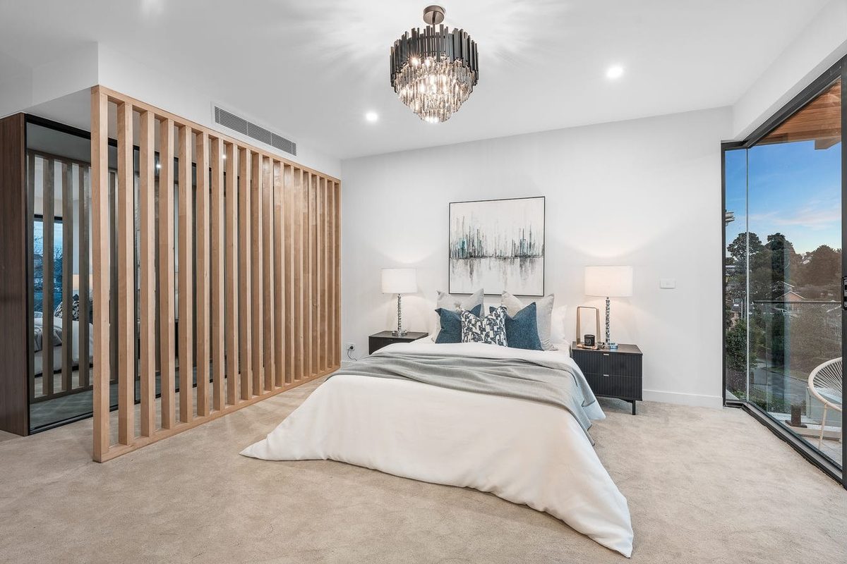 Bedroom with statement chandelier and timber feature wall lighting